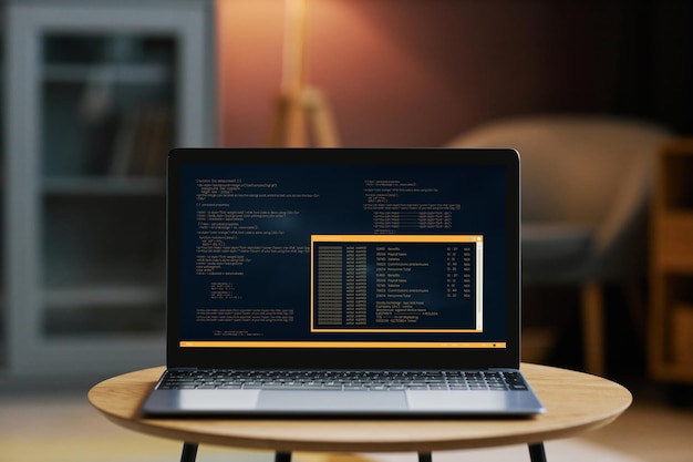 Open laptop with code on screen in dim home interior