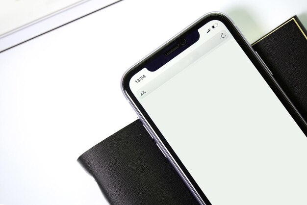 phone with black textured notebook on a white background View from above