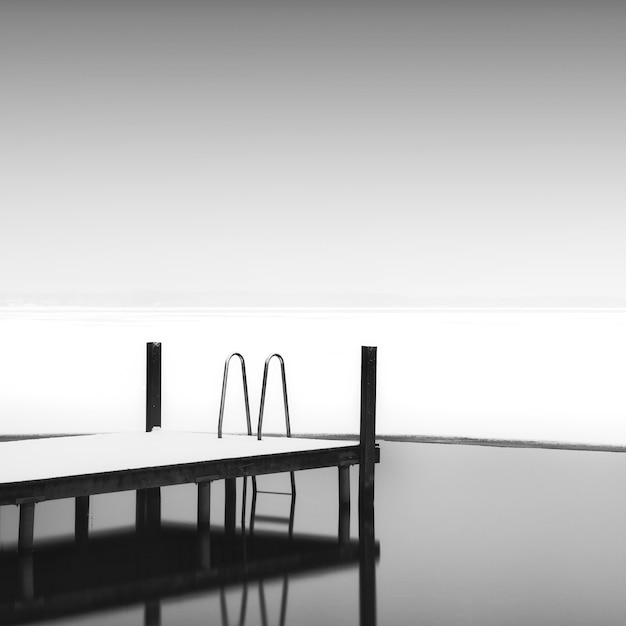 pier by frozen lake against sky