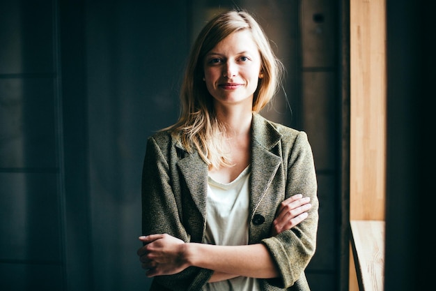 portrait of a smiling young woman with arms crossed