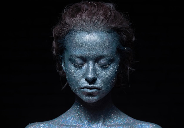 portrait of a woman with a blue face in glitter