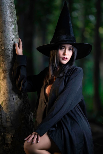 portrait of beautiful asian sexy woman wear black witch costume with broomhalloween festival concept
