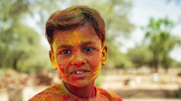 portrait of little boy playing with colors holi concept child covered in colored powder during the