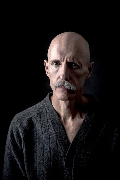 portrait of mature man against black background