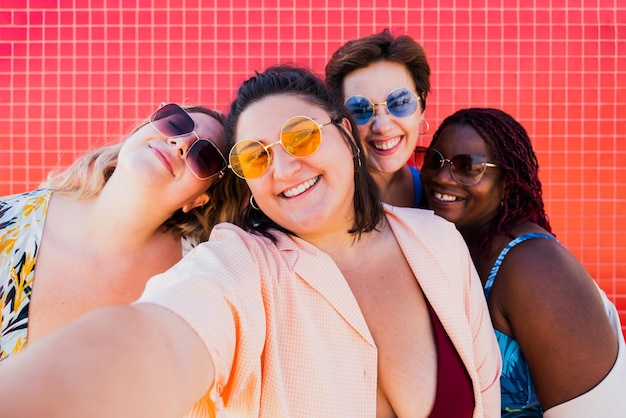 portrait of smiling friends standing against wall