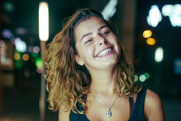 portrait of smiling young woman at night
