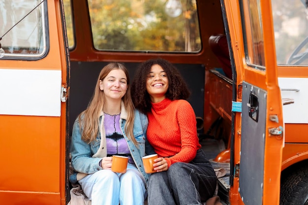portrait of smiling young woman standing in car
