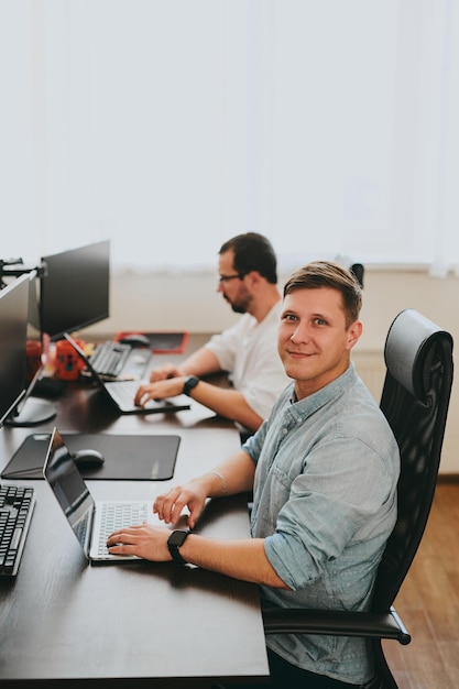 portrait of two professional male programmers working on computer in diverse offices modern it technologies development of artificial intelligence programs applications and video games concept