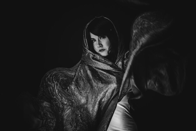 portrait of woman against black background