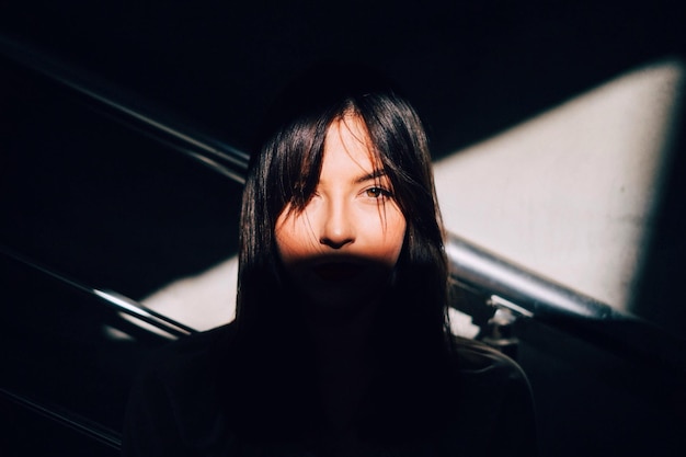 portrait of woman standing by railing against wall