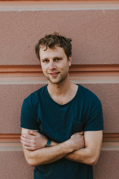 portrait of young man standing against wall