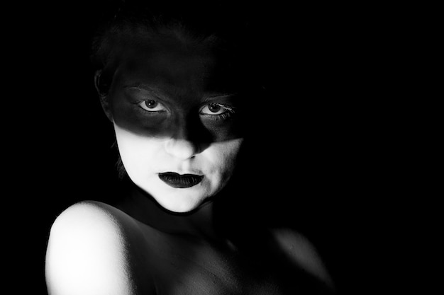 portrait of young woman against black background