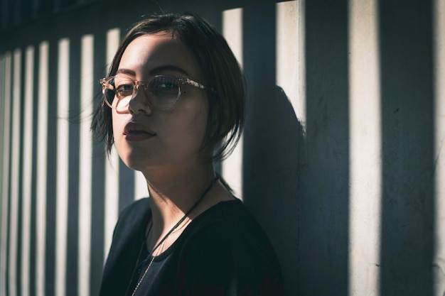 portrait of young woman standing against wall
