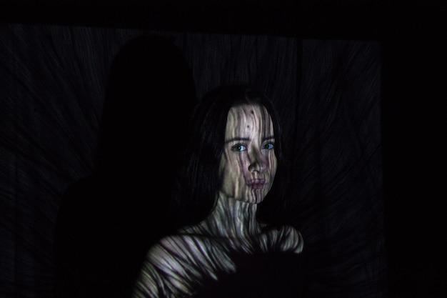 portrait of young woman with shadow in darkroom