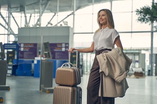pretty blonde woman demonstrating her smile while going to have business trip