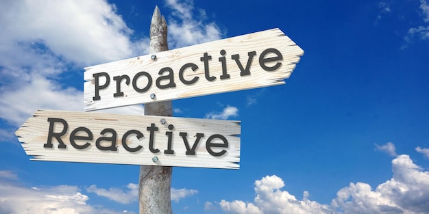 proactive reactive wooden signpost with two arrows