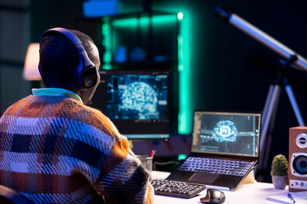 Professional male developer manages neural network at desk