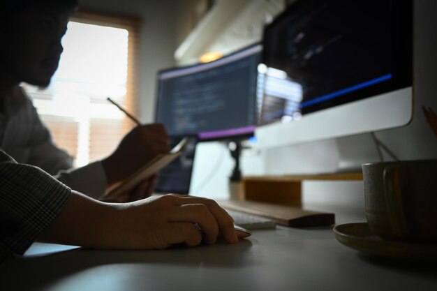 Professional software developers working on a new project writing program code on computer in office