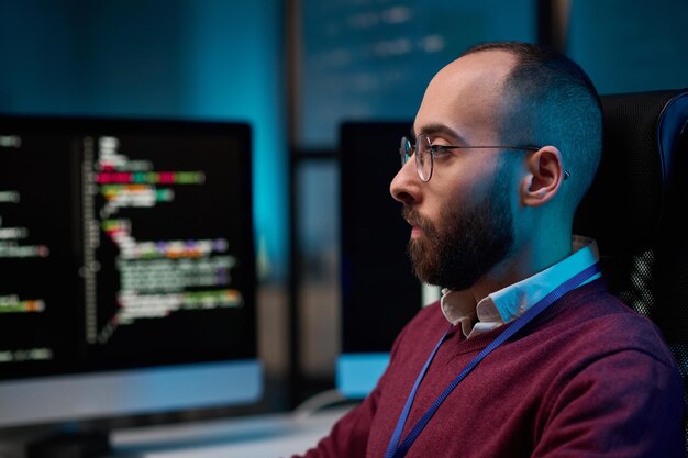 Profile View Bearded Man using Computer