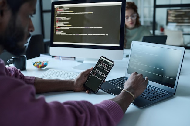 programmer connecting smartphone with laptop