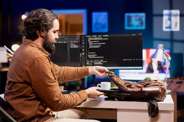 programmer packing backpack at end of day after securing company servers
