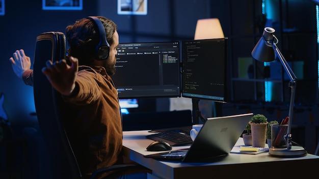 Programmer taking break from coding putting headphones on and stretching