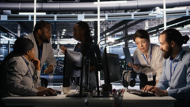 Programmers doing brainstorming in server room reviewing neural network code and llm visualization