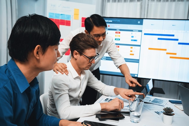 project manager communicate and collaborate with team using project management software display on monitor tracking progress of project task and making schedule plan at meeting table prudent