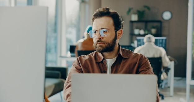 Reading computer and business man in office for software development online project or review Laptop serious or frontend developer with internet update creative problem solving or website design