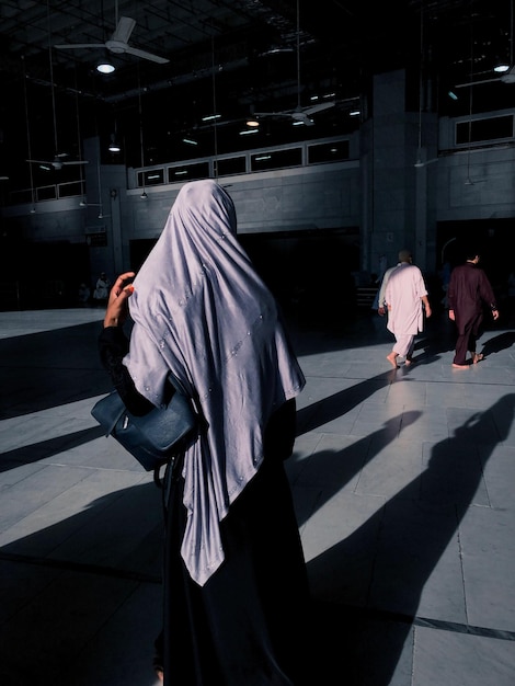 rear view of a muslim women walking on footpath