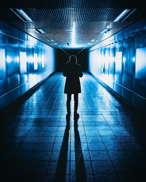 rear view of person standing in illuminated corridor