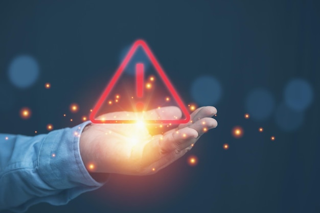 Red triangle caution warning signs on the hand of businessman for risk assessment of maintenance