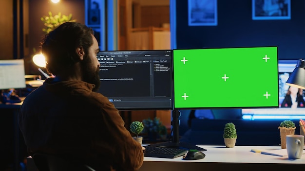 self employed man doing it support job coding on green screen pc