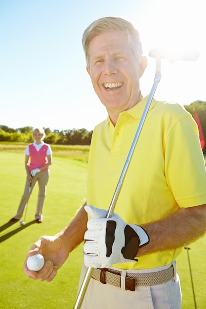 senior portrait and happy man with golf ball or club for game sports match or outdoor activity on grass field mature male person golfer or player with smile for competition or challenge on course