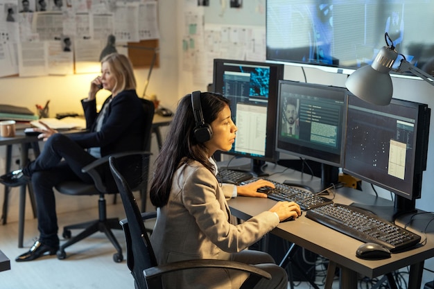 serious agent of intelligence service sitting in front of computer monitors