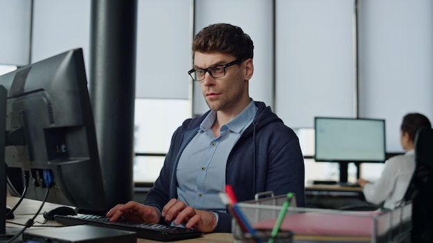 Serious it guy typing computer in office professional programmer code using two