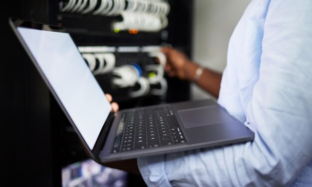 Server room laptop and IT technician man with internet connection for software programming Male engineer person with technology for cybersecurity problem solving or system update in data center