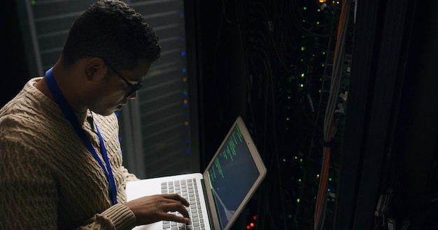 Server room laptop and technician man for coding cybersecurity update or online machine system IT support data center and screen of engineer for network information technology and service