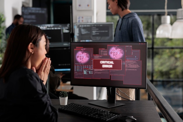 shocked programmer typing html code encountering hacking alert on computer, dealing with unexpected system error and message flashing on monitor. cyber security development office.