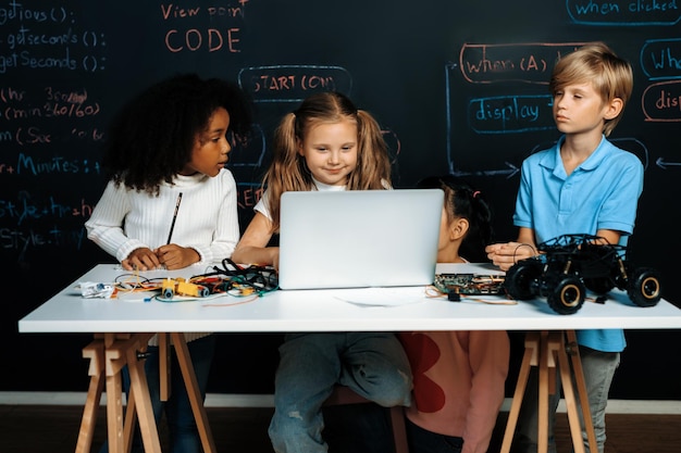 Smart girl in white bib learning robotics technology using laptop erudition