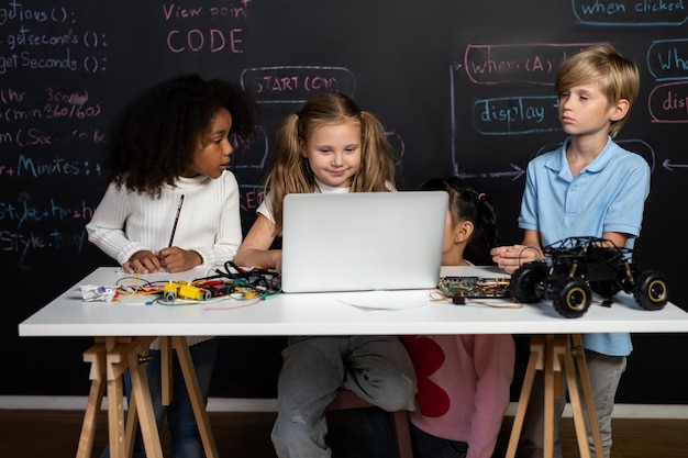 Smart girl in white bib learning robotics technology using laptop erudition