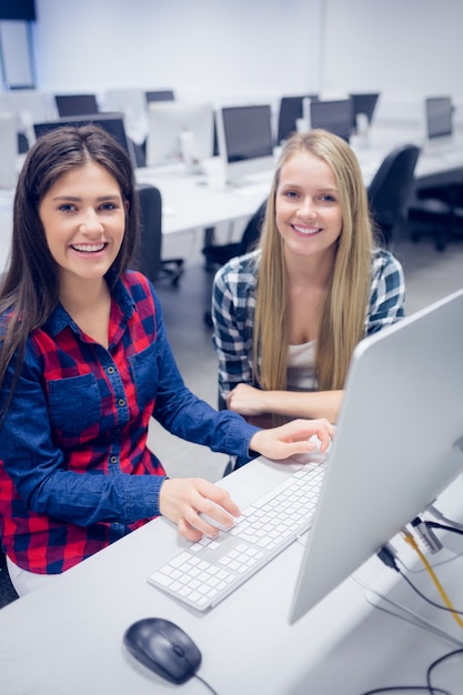 smiling students using computer at university 
