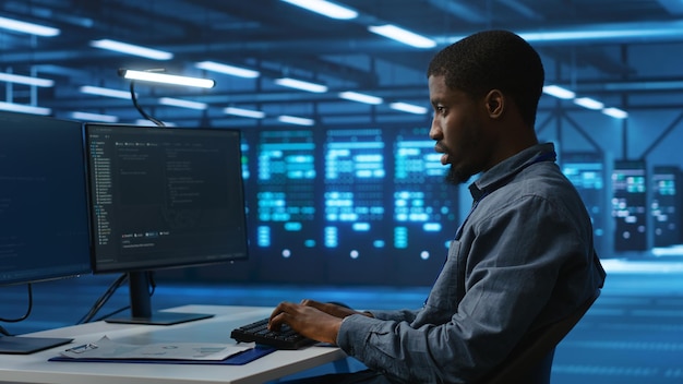 Software developer programming in high tech facility with server rows