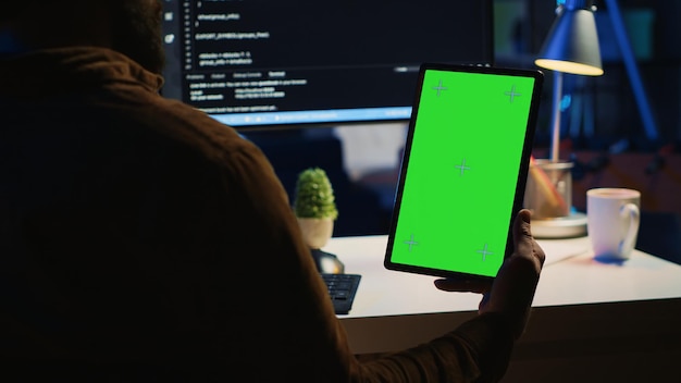 software developer programming in home office with green screen tablet