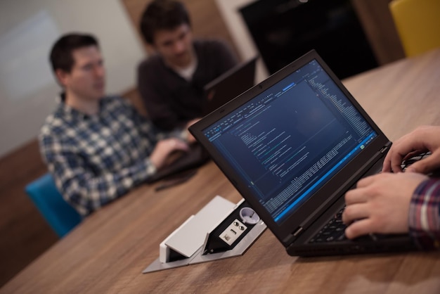 software developer writing programming code on laptop computer