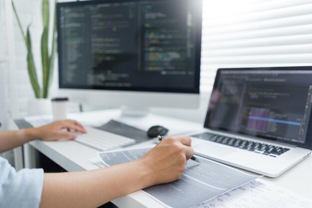 Software development concept male programmer pointing on data code to checking website programming