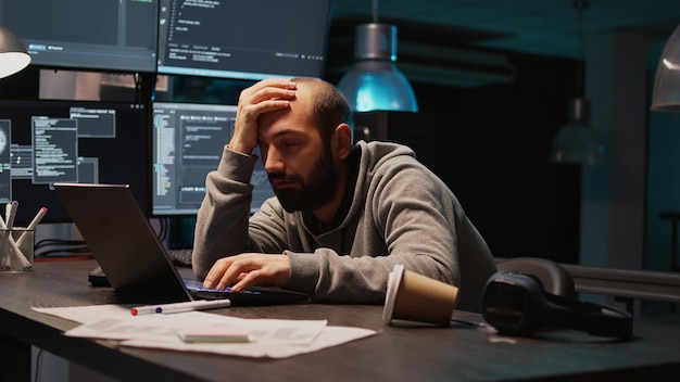 Software engineer yawning and falling asleep on desk, being exhausted and trying to work on new interface programming. Man feeling sleepy and tired late at night, using server code. Handheld shot.