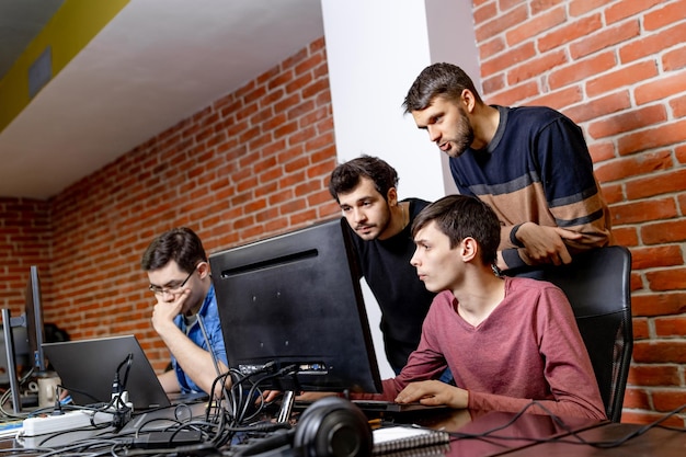 Software engineers working on project and programming in company. Company of developers looking at the computer screen. Website design and brainstorming concept.