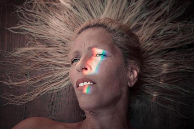 spectrum on face of woman lying on wood