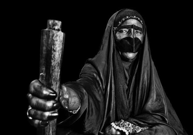 spooky woman wearing mask against black background